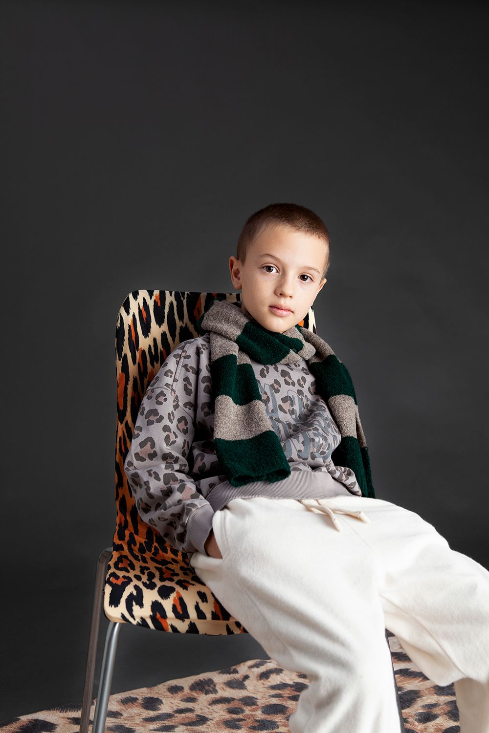 jongen met een trui met leopard print en sjaal