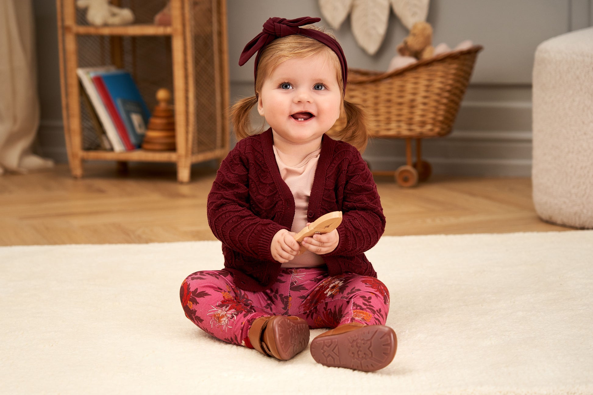 baby met donker rode cardigan en bijpassende haarband